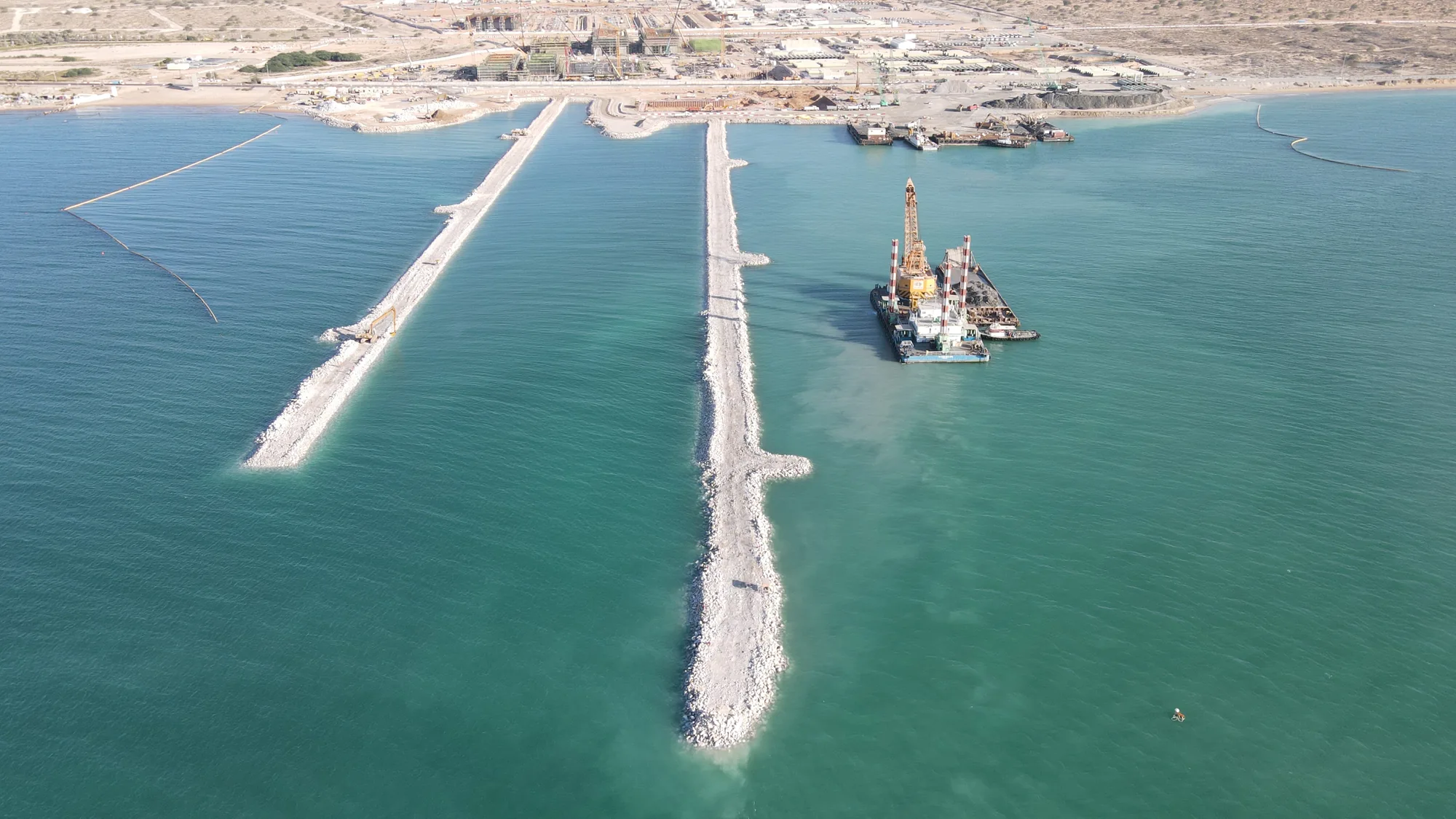 Aerial view of the intake channel and rock breakwaters at NAQAA, Umm Al Quwain.
